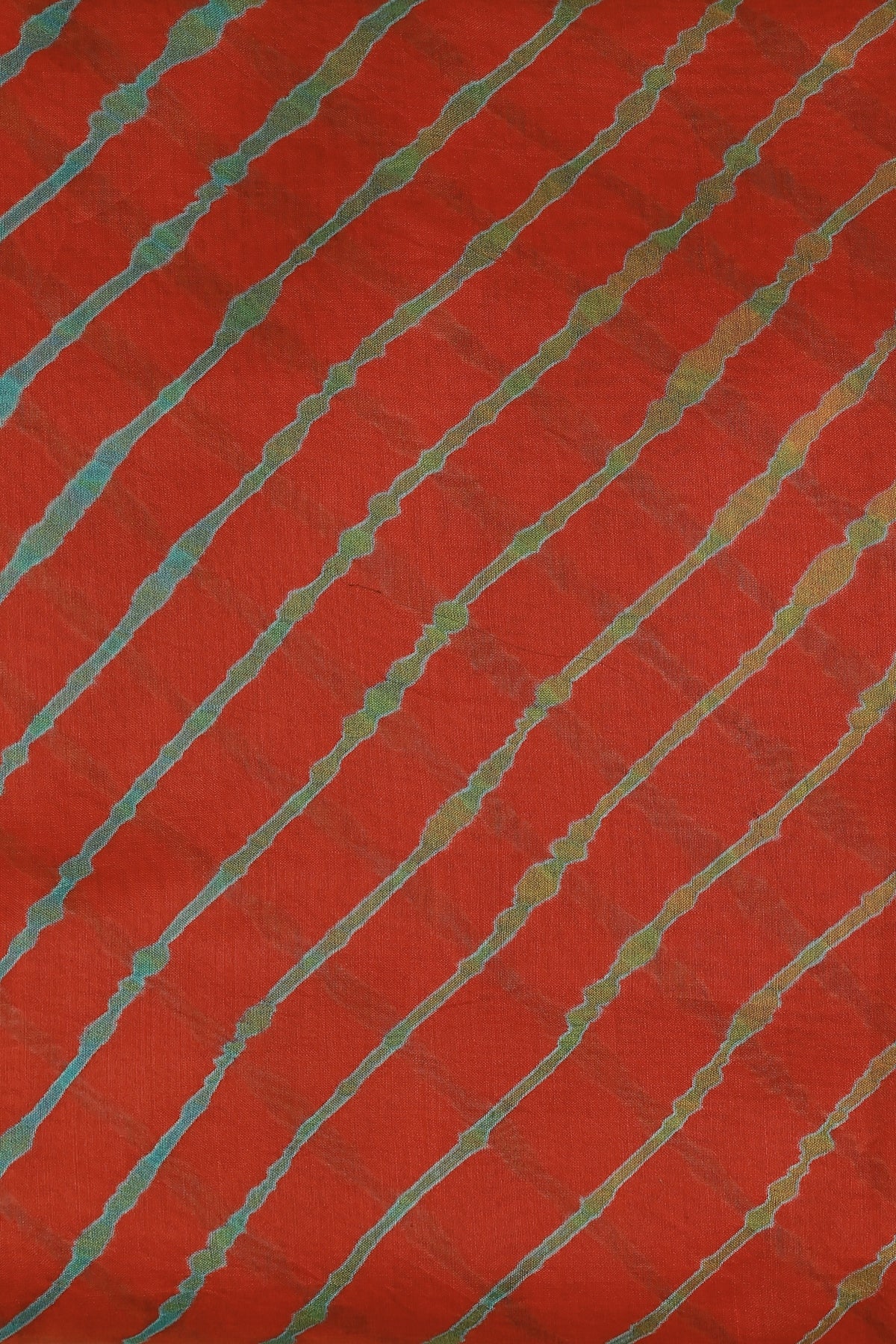 Orange-red saree with multicoloured diagonal Lahariya stripes and a narrow metallic border
