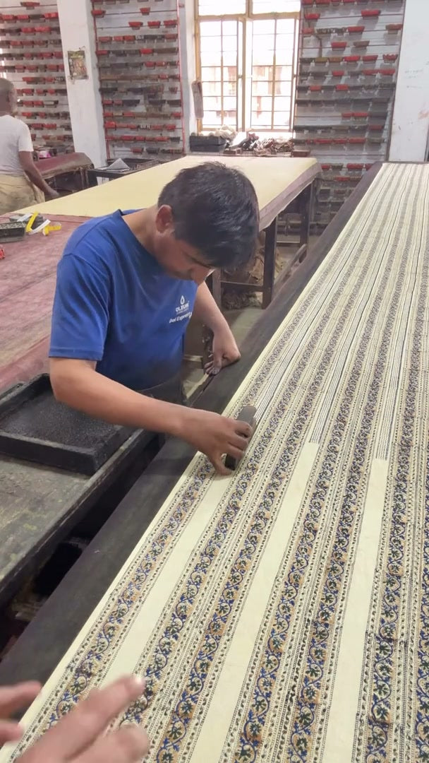 An artisan hand-printing cloth at the workshop Rekha visited
