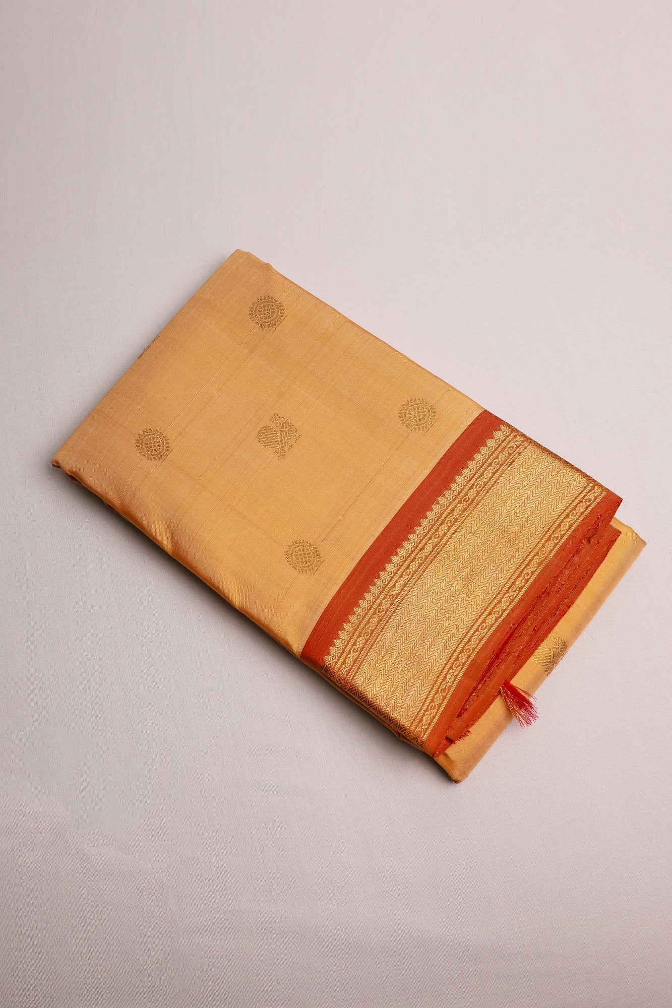 Sandalwood Kanjeevaram Saree with Light Orange Zari Border Mayil Chakram Buttas on Body