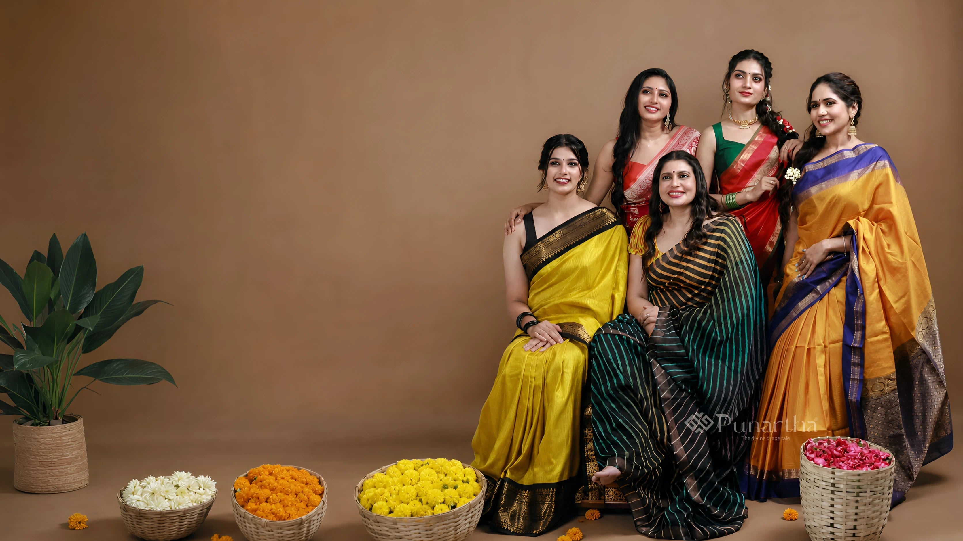 Five women gathered in richly coloured handwoven sarees