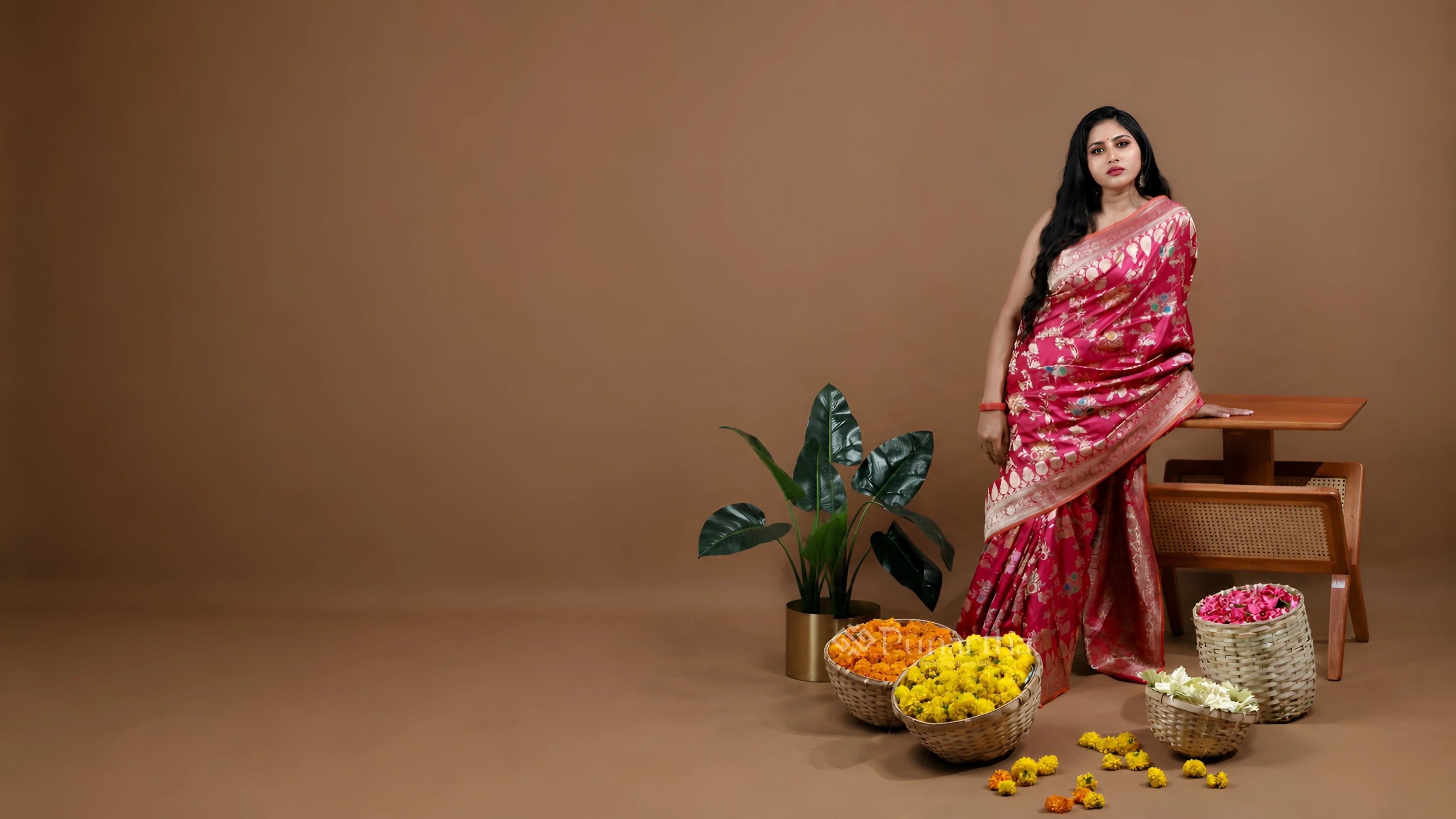 Woman standing confidently in a vivid pink handwoven saree